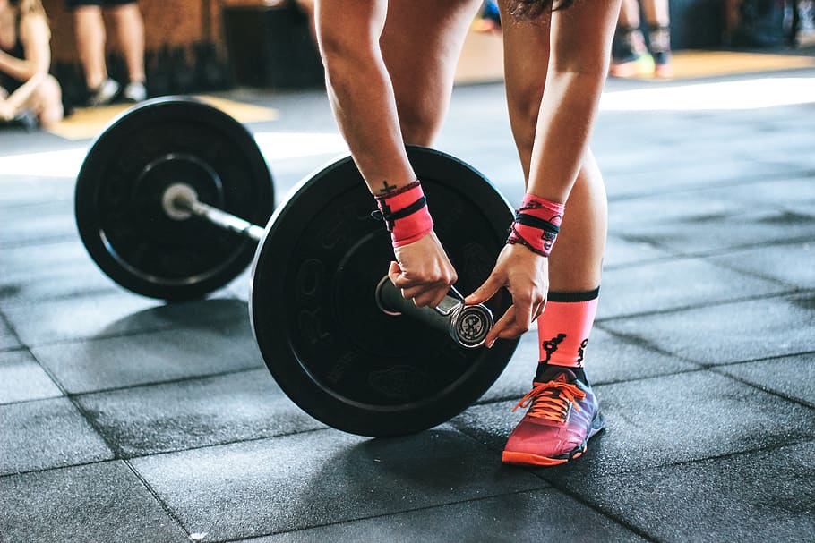 person-locking-gym-plates-on-barbell